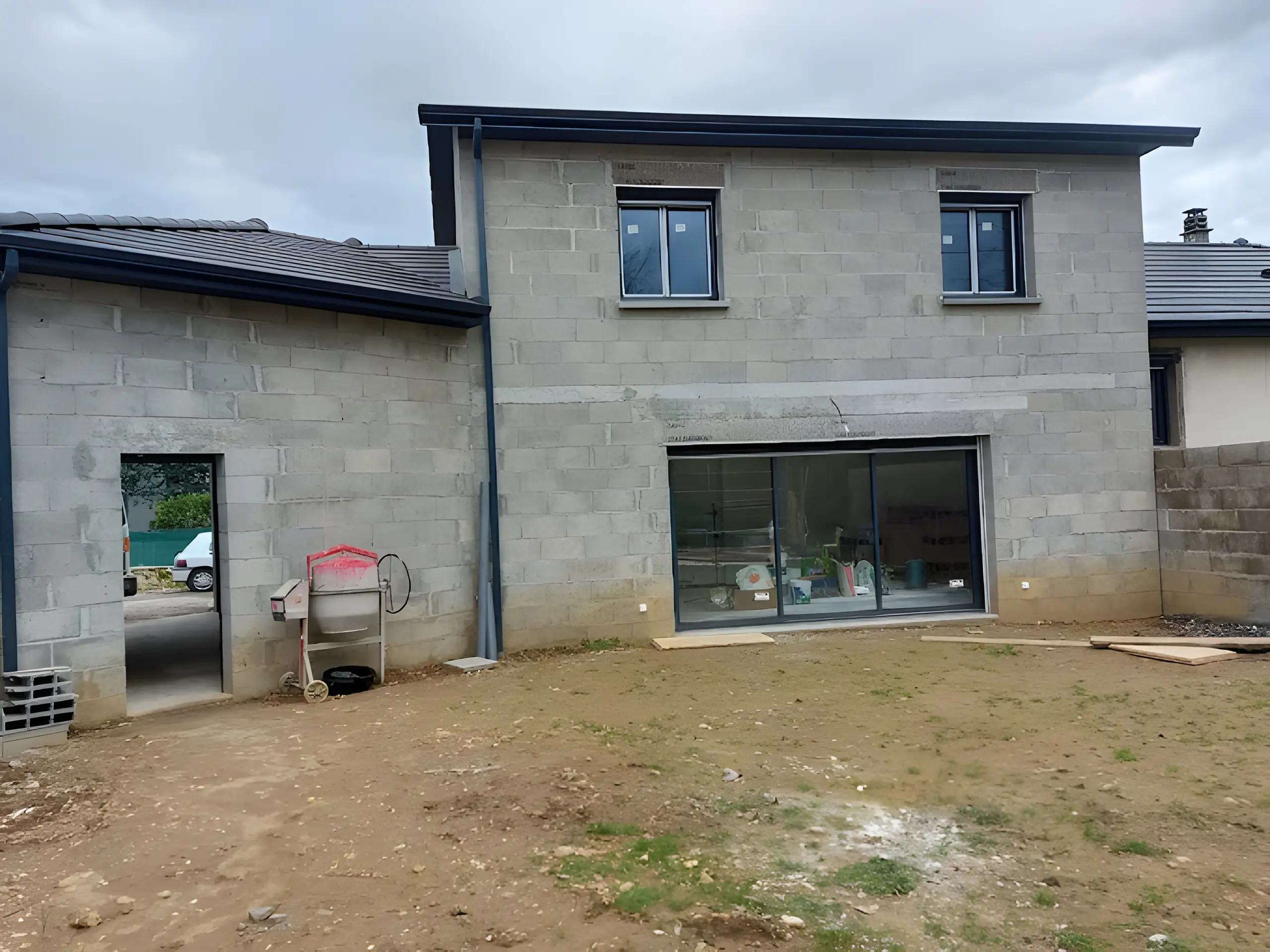 Maison à étage en parpaings avec fenêtres et grande baie coulissante posées